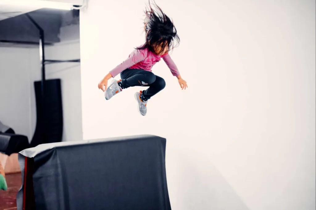 Adorable Young Girl Overcoming Obstacle with Joyful Leap
